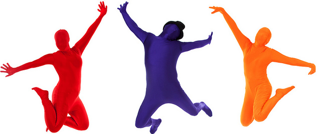 photo of people leaping in air, clothed in full-body colour leotards