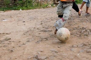 Photo of shoeless children playing soccer in the dirt  by Danumrthi Mahendra used under CC BY-2.0 license.