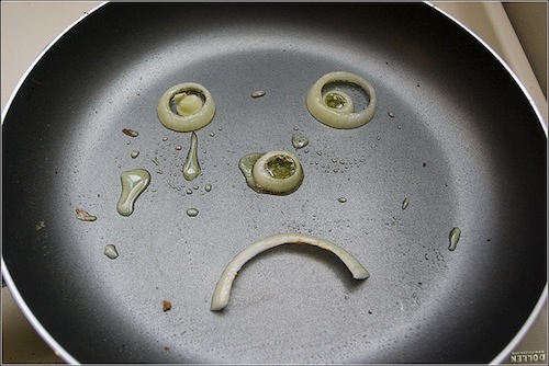 photo of onion slices in a frying pan making a crying face