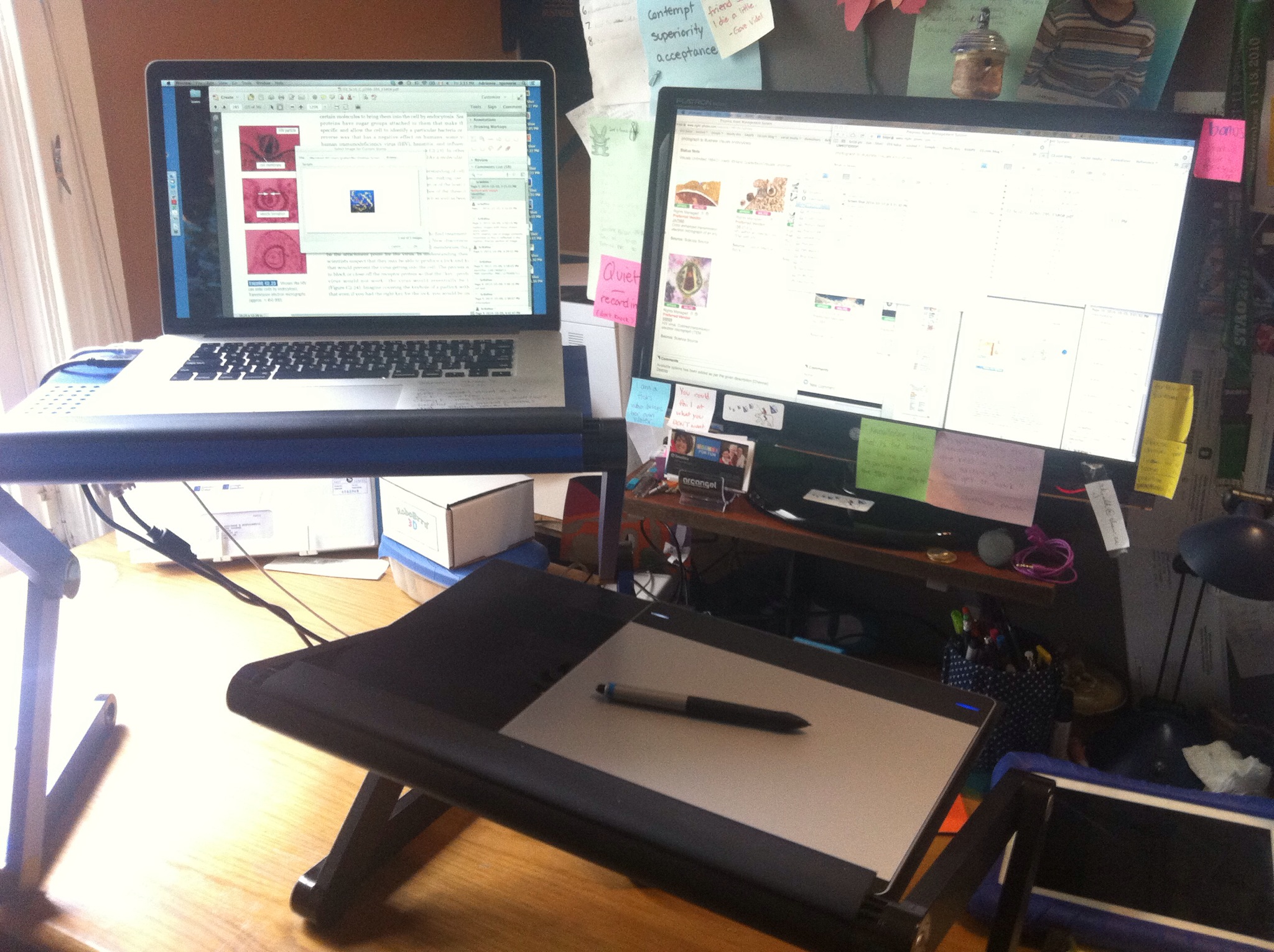 desk setup of dual screens and touch/stylus pad on standing desk arrangemetn