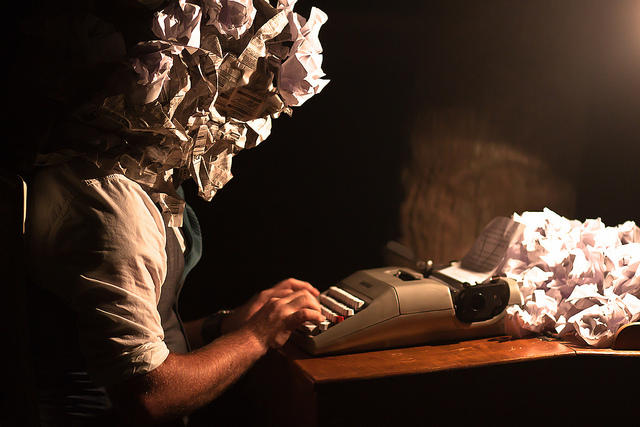 Photo of crumpled-paper-head writer with typewriter