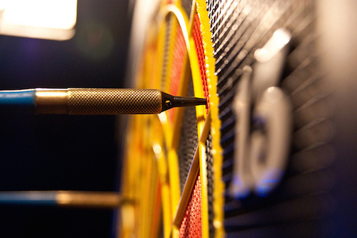 close up photo of darts in a dart board