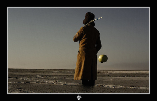 surreal photo of a person with a green apple on a fishing rod