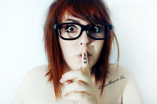 Woman holding her shh finger to her lips