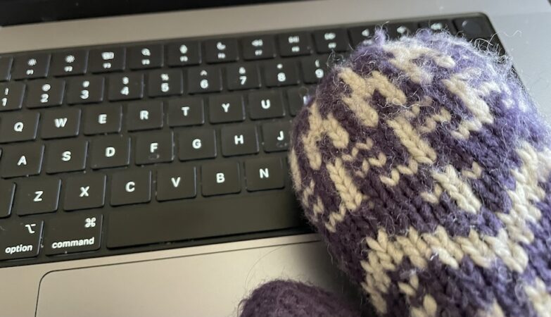 a knitted mitten on a computer keyboard